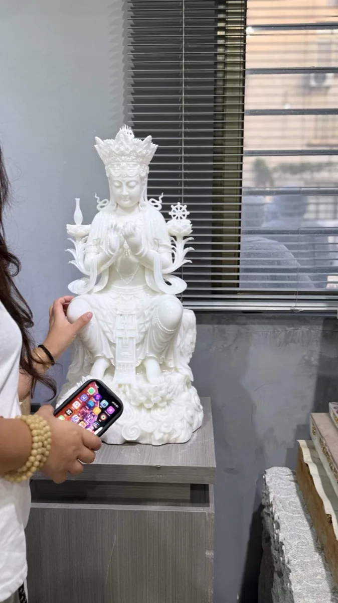 Large carved Guanyin figure standing in the workshop