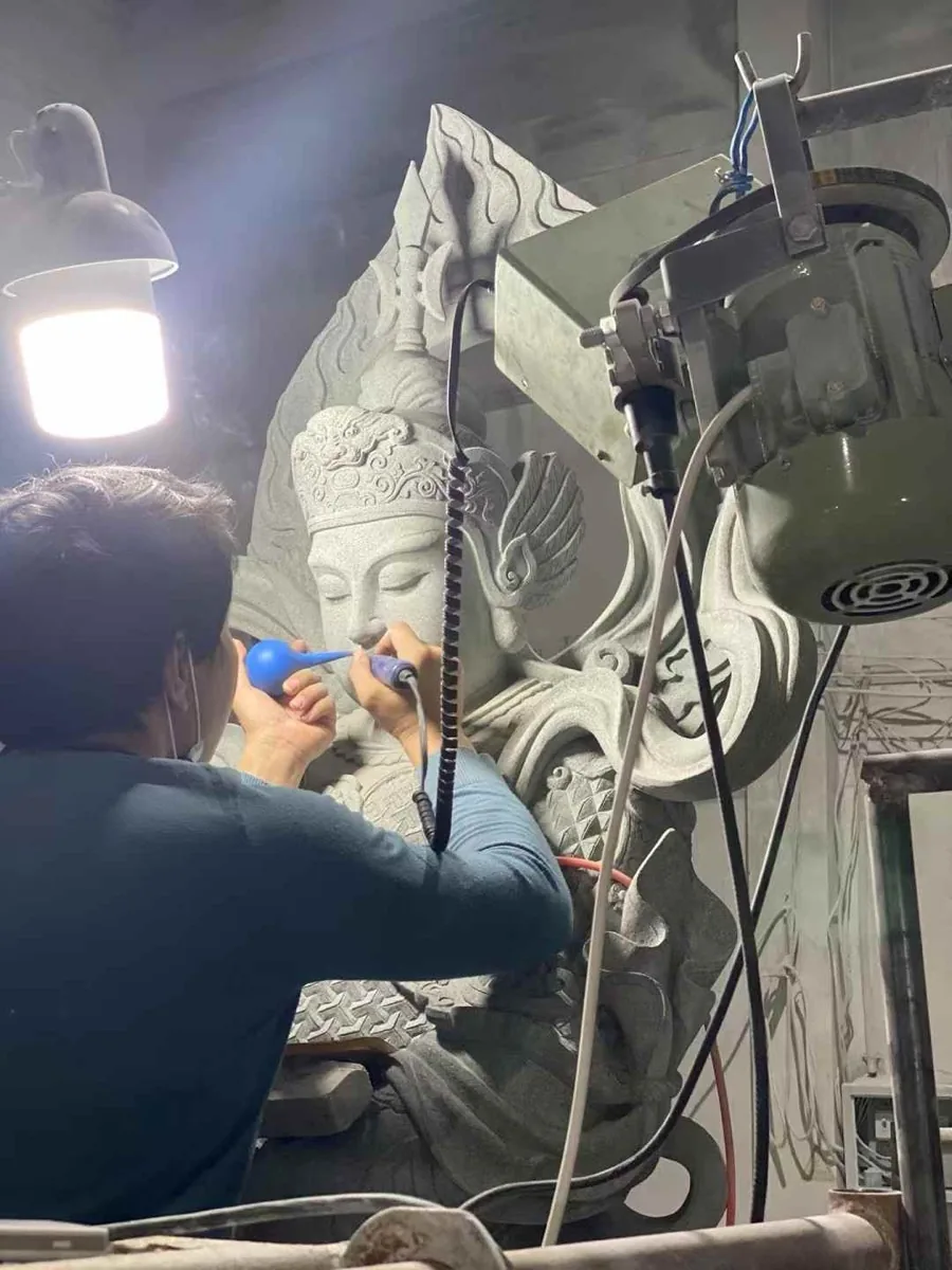 Close tooling work on a grey granite carving